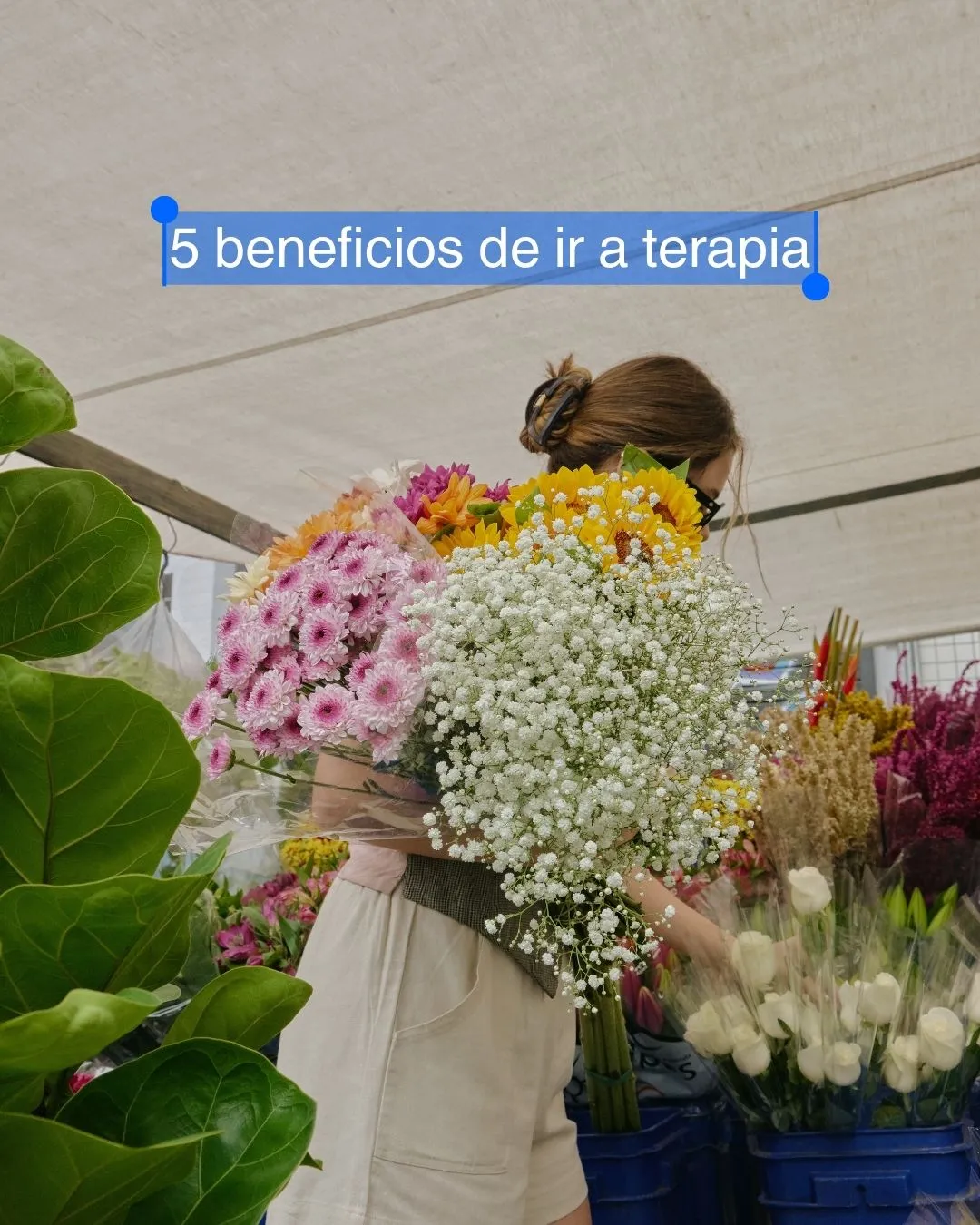 Mujer sosteniendo un gran ramo de flores en un puesto de mercado, con el texto «5 beneficios de ir a terapia»